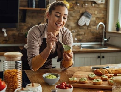 Woman putting guacamole on a toast