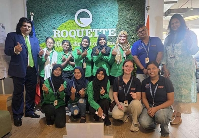Group of people posing in front of a Roquette logo wall