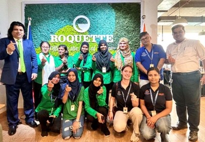 Group of people posing in front of a Roquette logo wall