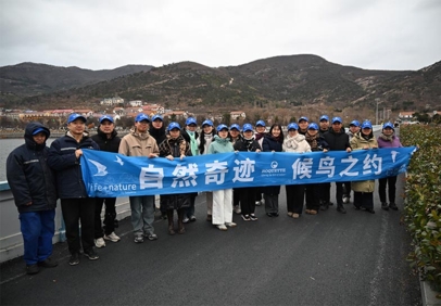 Roquette employees hold a blue “Preserve the planet” banner during a birdwatching field visit in wetlands near Lianyungang, China.