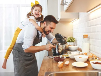 A girl cooking with her father