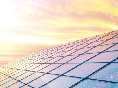 Solar panels aligned in several rows stand out against a sunset sky.