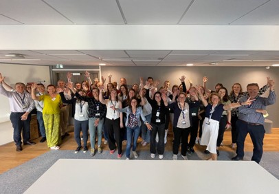 A group of Roquette people celebrating in an office with raised arms and smiling faces.