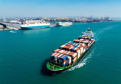 Aerial view of container ship at a busy ocean port.