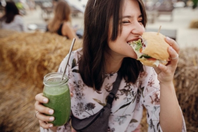 roquette-food-woamn-eating-veggie-burger-and-drinking-smoothie