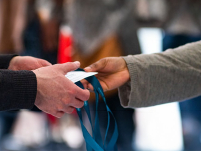 Two people exchanging a badge or pass.