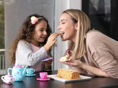 Girl giving cake to her mother