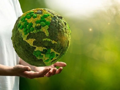 A man holding a globe with continents represented by plants.