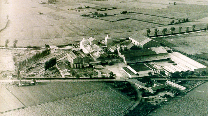 Vue aérienne ancienne du site industriel de Lestrem parmi les terres agricoles et les champs ouverts.