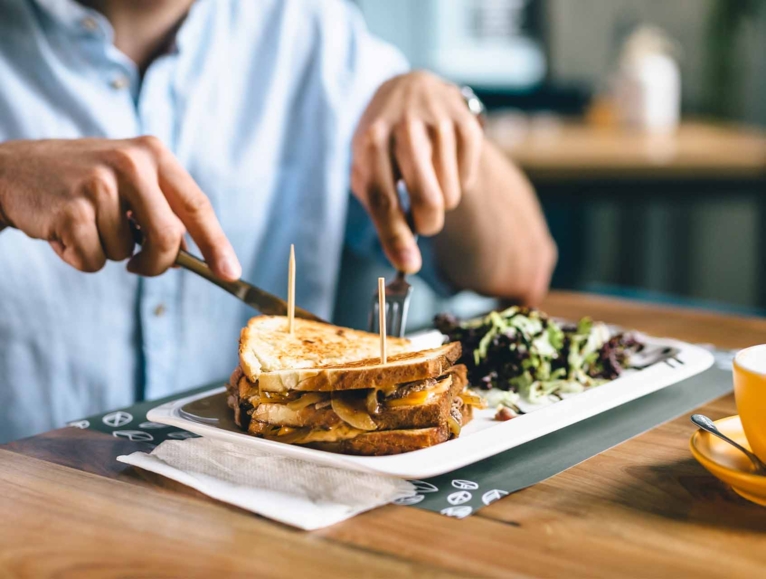 men cutting a sandwich