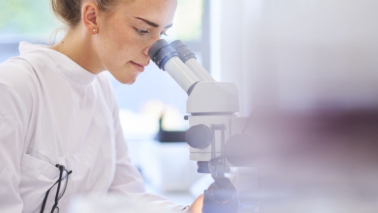 woman looking in a microscope