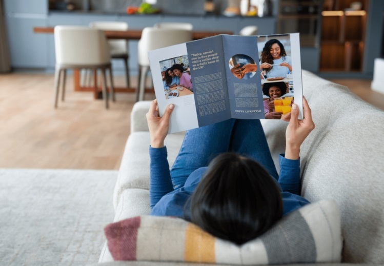 A woman on the couche reading a magazine
