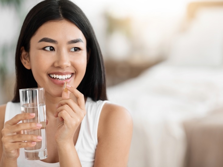 Consumer taking softgel capsule to support modern health and nutrition goals