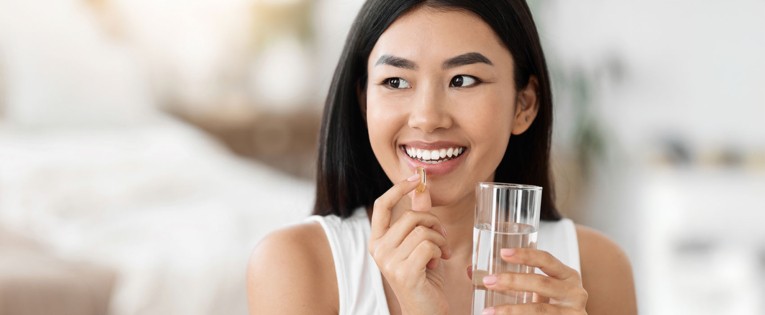 Consumer taking softgel capsule to support modern health and nutrition goals